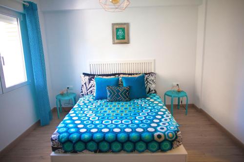 um quarto com uma cama azul com almofadas azuis em Apartment near the beach em Alicante