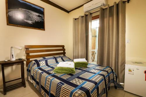 1 dormitorio con 1 cama con 2 almohadas en Espaço Dona Florinha, en Ilhabela
