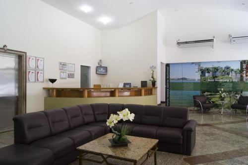uma sala de estar com um sofá e uma mesa em Apart Guarapari Residence - Areia Preta em Guarapari