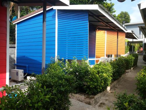 a colorful house in a yard with bushes at Sripech Home in Sangkhla Buri