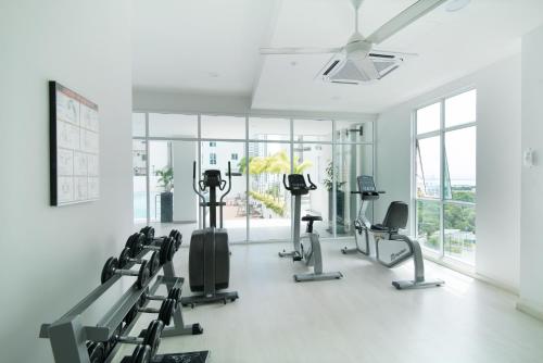 een fitnessruimte met cardio-apparatuur in een kamer met ramen bij Straits Garden Suites, Georgetown in George Town