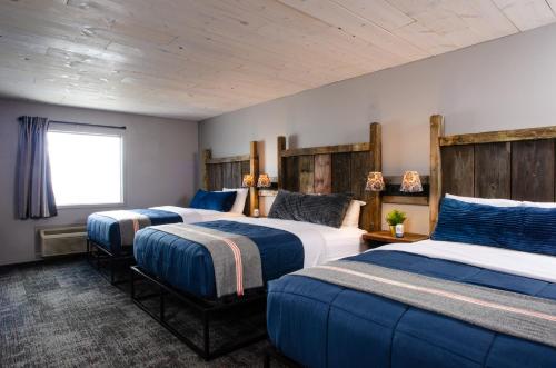 a bedroom with two beds and a window at Vintage Block Inn & Suites in Okoboji