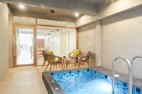 a room with a swimming pool and a table and chairs at Vann House Hua Hin in Hua Hin