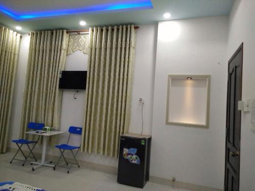 a room with a television and chairs and a table at Khách sạn Hương Sen Sa Đéc in Sa Ðéc