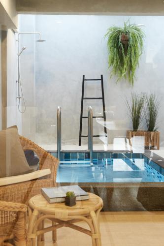 a pool in a room with a table and some plants at Vann House Hua Hin in Hua Hin