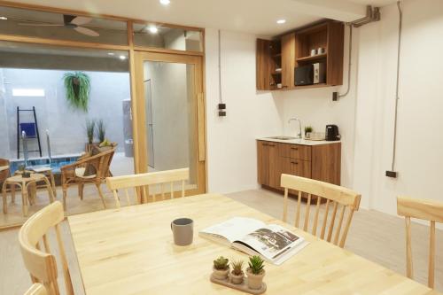 a kitchen and dining room with a wooden table and chairs at Vann House Hua Hin in Hua Hin