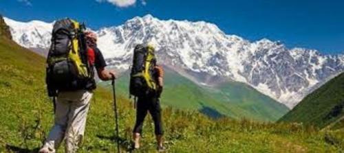two people with backpacks looking at a snow covered mountain at S Group Of Houseboat in Srinagar