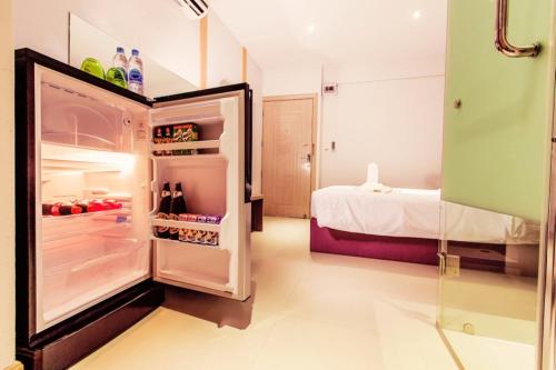 an open refrigerator in a room with a bed at D Day Suite in Bangkok