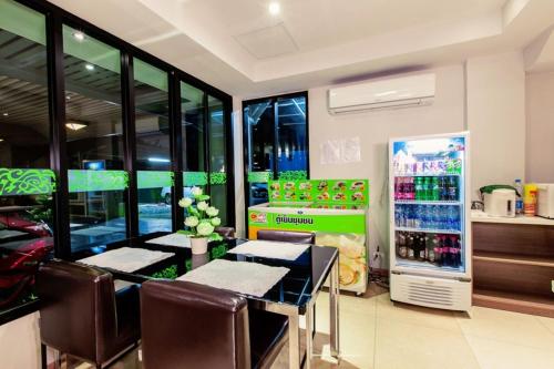a restaurant with a table and chairs and a refrigerator at D Day Suite in Bangkok