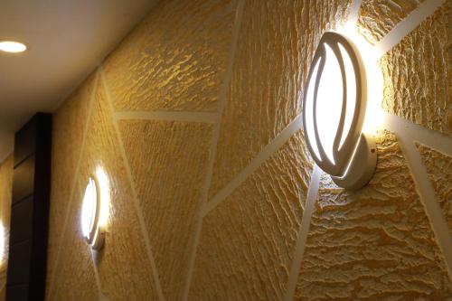 a bathroom with two lights on a wall at Anna Residency in Nedumbassery