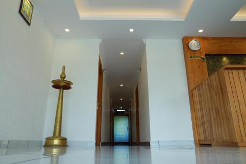 a hallway with a door and a clock in a building at Anna Residency in Nedumbassery