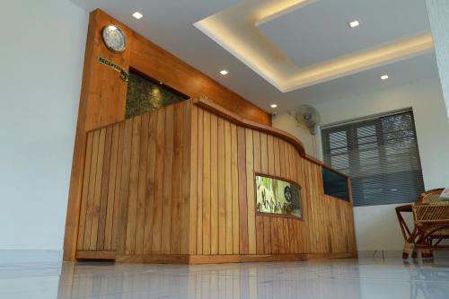 a room with a wooden wall with a clock on it at Anna Residency in Nedumbassery
