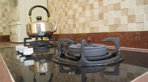 a stove with a tea kettle on top of a counter at Homestay / Guest House Dekat Malioboro in Yogyakarta
