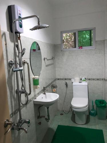 a bathroom with a toilet and a sink at All Care Bed and Breakfast in Tagaytay