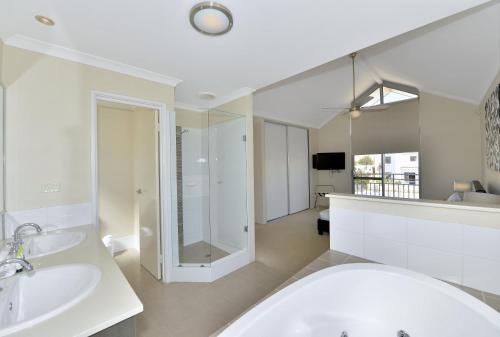 ein Badezimmer mit zwei Waschbecken und einem großen Spiegel in der Unterkunft Serenity on the Terrace in Mandurah