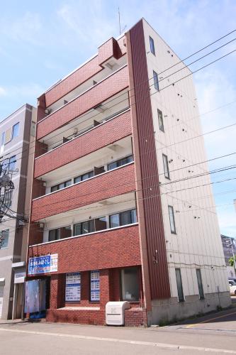 a red brick building on the side of a street at Apartment Susukino Hakuhou Building in Sapporo