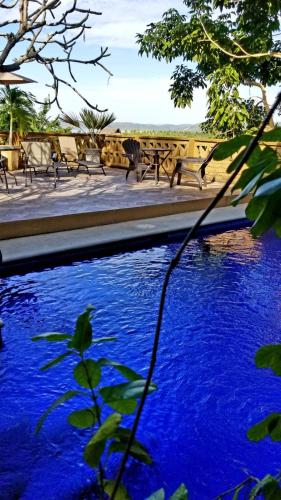 a pool of blue water with benches in the background at Casa Maria en La Manzanilla in La Manzanilla
