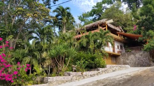a house with a bunch of flowers in front of it at Casa Maria en La Manzanilla in La Manzanilla
