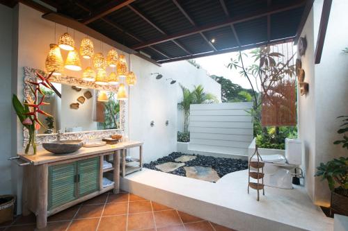 a bathroom with a sink and a toilet and a mirror at Sunset Paradise Villa Jimbaran 8008 in Jimbaran