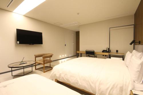 a hotel room with two beds and a flat screen tv at Hotel Eco stay in Jeonju