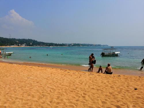 a group of people standing on a beach at Villa Ok in Unawatuna