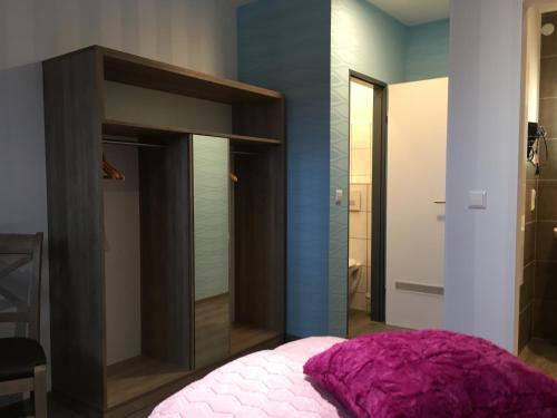 a bedroom with a pink bed and a mirror at Astrid's Pension in Winterberg