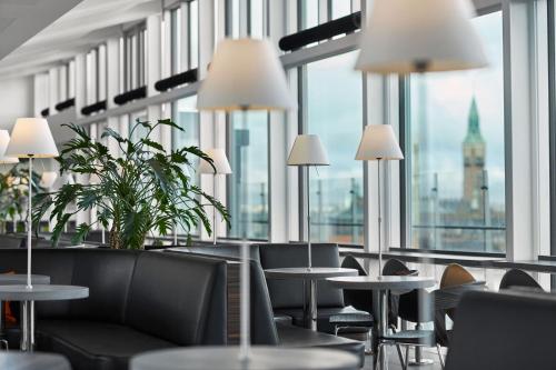 a restaurant with tables and chairs and large windows at Wakeup Copenhagen - Bernstorffsgade in Copenhagen