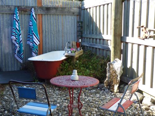 a garden with a table and chairs and a bath tub at Hapuku Carriages Kaikōura in Kaikoura