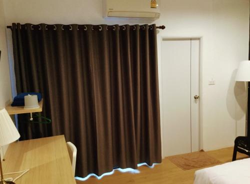 a black curtain in a room with a bedroom at The Resto in Udon Thani