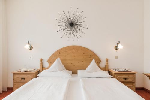 a bedroom with a large white bed with white sheets at Pension Monika in Lagundo