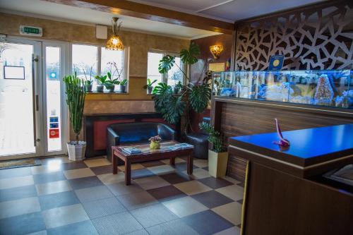 a restaurant lobby with a blue counter and plants at Motel Davios in Târgu Jiu
