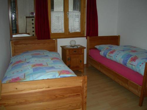 a bedroom with two twin beds and a mirror at Ninetta in Valchava