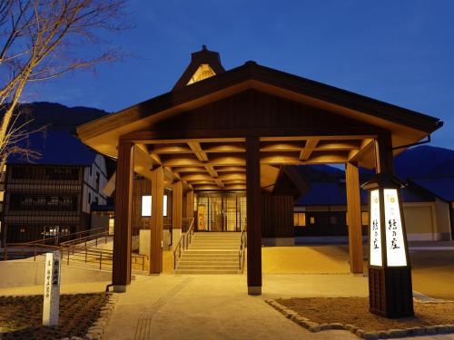 a building with a pavilion with a staircase in front at Onyado Yuinosho, Shirakawago in Shirakawa