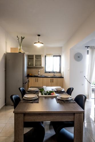 a dining room with a wooden table and chairs at Holy Paraskevi Apartment in Agios Nikolaos