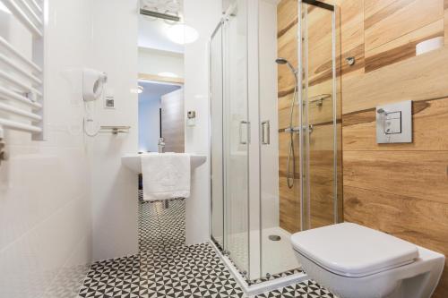 a bathroom with a shower and a toilet and a sink at Villa Nova in Białystok