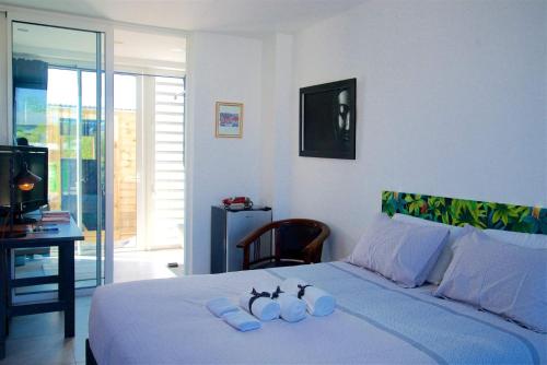 1 dormitorio con 1 cama con 2 toallas en Maison TONGA piscine jaccuzi, en Saint-Pierre