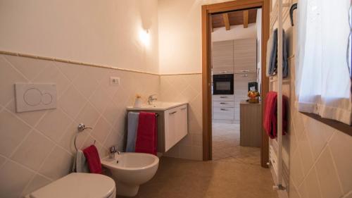 een badkamer met een wit toilet en een wastafel bij Appartamenti La Casina in Porto Azzurro