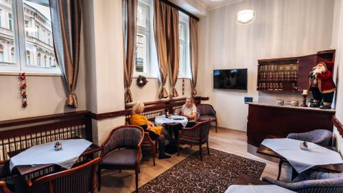 two people sitting at a table in a restaurant at Star Hotel in Karlovy Vary