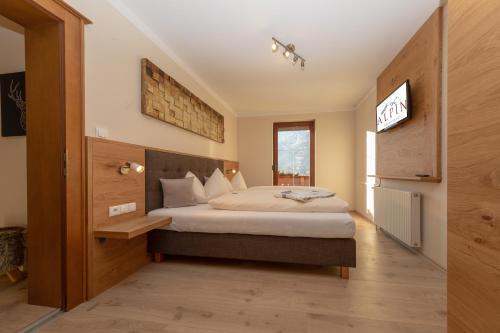 ツェル・アム・ツィラーにあるResidence Alpinのベッドとテレビが備わるホテルルームです。