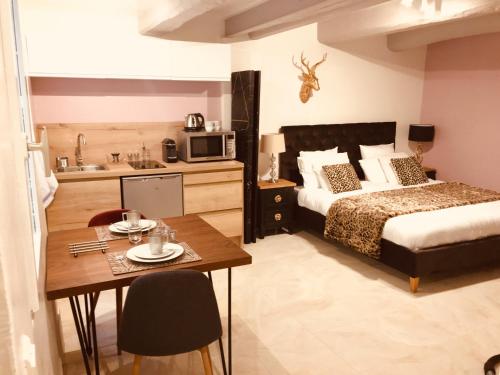 a bedroom with a bed and a table and a kitchen at Artistic Antibes Apartment in Antibes
