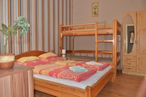 a bedroom with two bunk beds and a ladder at Homokháti Apartman in Mórahalom