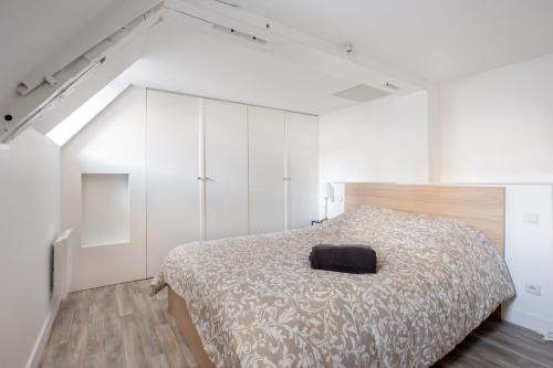 ein Schlafzimmer mit einem Bett mit einem schwarzen Kissen darauf in der Unterkunft Coeur de Lille - cosy appartement 5 in Lille