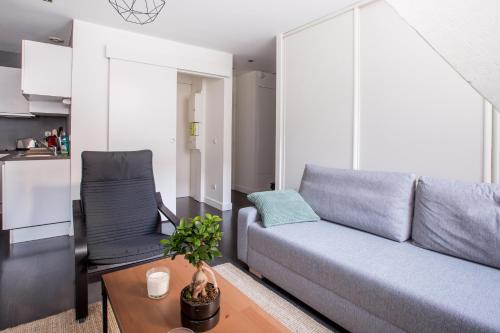 un salon avec un canapé et une chaise dans l'établissement Coeur de Lille - cosy appartement 5, à Lille