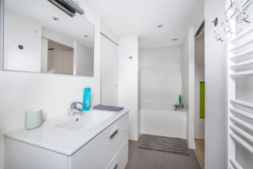 リールにあるCoeur de Lille - cosy appartement 4の洗面台と浴槽のある白いバスルーム
