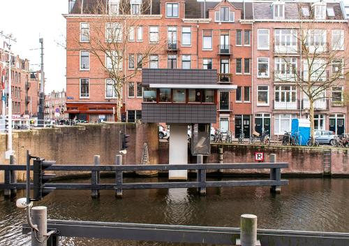 a small building in the middle of a body of water at SWEETS - Zeilstraatbrug in Amsterdam