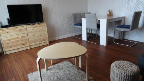a living room with a table and a tv at Studio moderne avec jolie vue in Moulins