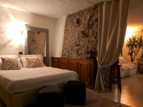 a bedroom with a bed and a stone wall at Casa al Riccio in Capolona