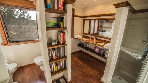 a bathroom with a toilet and a book shelf with books at Cigarral de la Encarnación in Toledo
