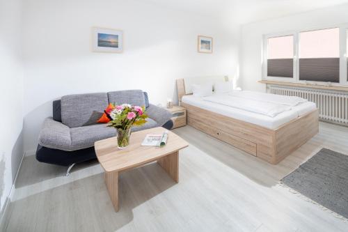 ein Schlafzimmer mit einem Bett, einer Couch und einem Tisch in der Unterkunft Ferienhaus an der Karlstraße in Norderney