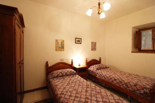 a hotel room with two beds and a lamp at Casale Aiola in Poggioni